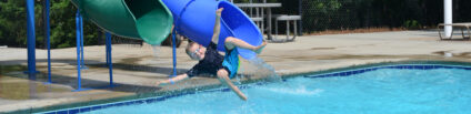boy on pool slide